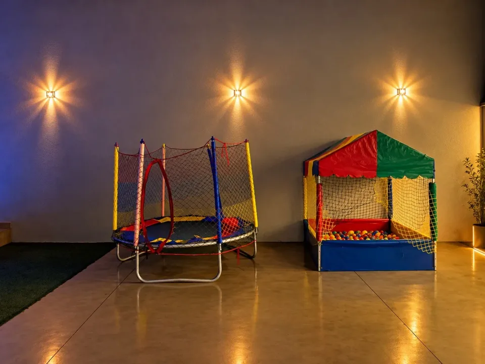 Cama elástica e piscina de bolinhas iluminadas à noite