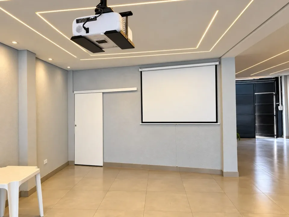 Projetor no teto e telão de projeção